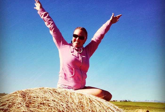 Shannon Fisher on a hay bale looking happy