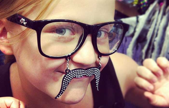 Emma with dark rim glasses and fake mustache