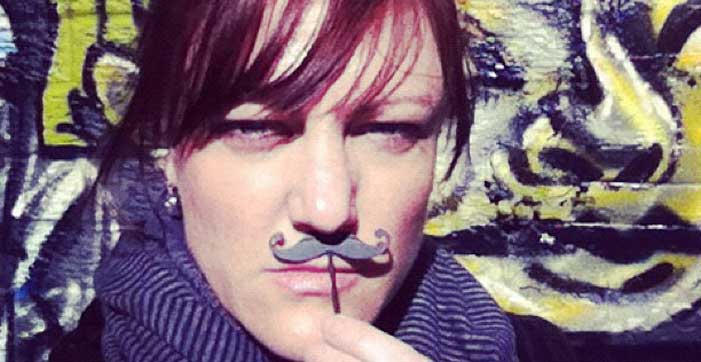Shannon Fisher holding up a fake movember moustache
