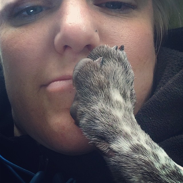 close up of shannon's face with a dog's paw on her mouth